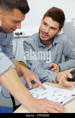 plumber writing on clipboard by electric boiler Stock Photo