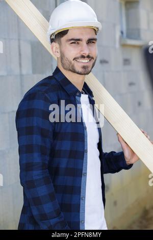 happy young man as builder carrying wood and working Stock Photo