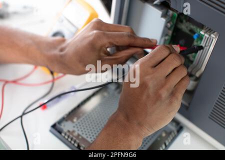 engineer checking motherboard with multimeter close up Stock Photo