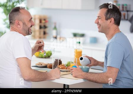 young gay couple have breakfast in the kitchen Stock Photo