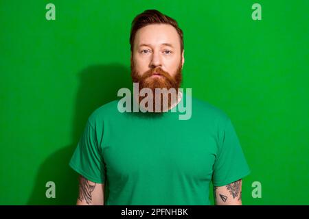 Photo of focused concentrated person calm face look camera isolated on vibrant green color background Stock Photo
