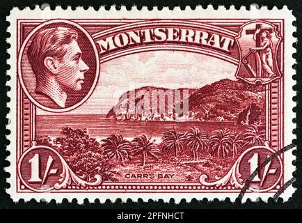 MONTSERRAT - CIRCA 1938: A stamp printed in Montserrat from the 'Landscapes, King George VI & Coat of Arms' issue shows Carrs Bay, circa 1938. Stock Photo