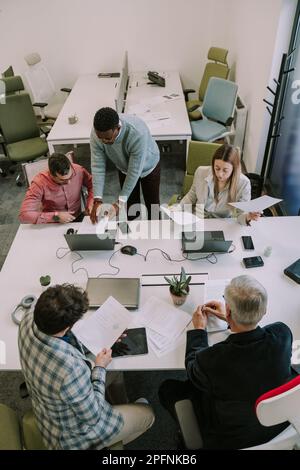 Five businesspeople discussing about their upcoming job at the office Stock Photo