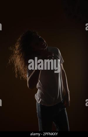 Beautiful man is fixing his long wavy hair. Studio shoot Stock Photo