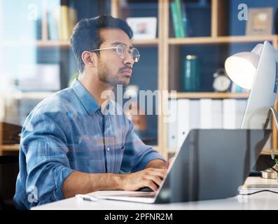 Serious, business man typing on laptop, computer and software development, online research or information technology. App developer or asian person on Stock Photo