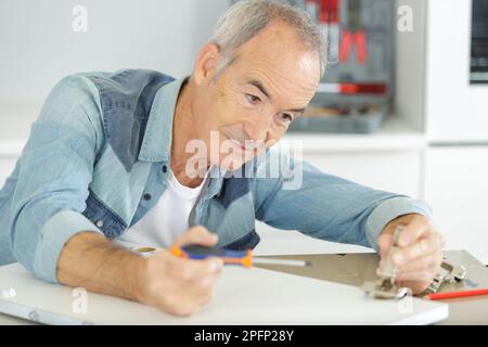 senior assembling furniture at home Stock Photo