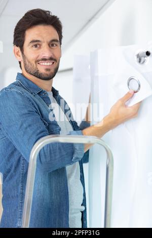 man hanging curtains on the rail Stock Photo