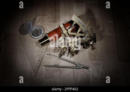 old sextant, spyglass, circle and compass lying on wooden table Stock Photo