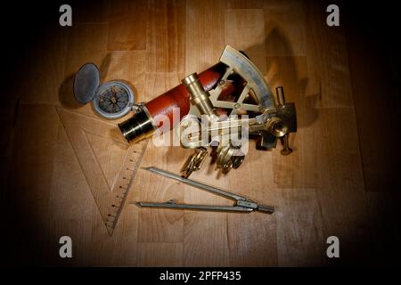 old sextant, spyglass, circle and compass lying on wooden table Stock Photo