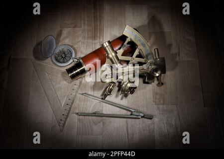 old sextant, spyglass, circle and compass lying on wooden table Stock Photo