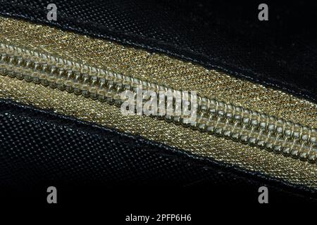 Golden zipped on a black background , Golden plastic zipper Stock Photo
