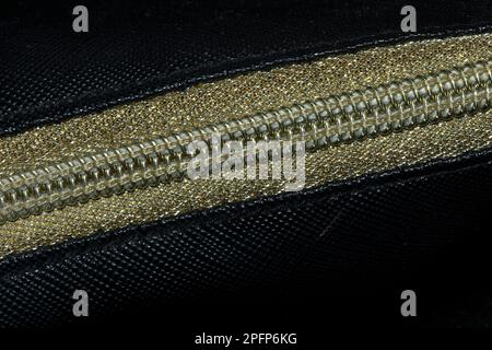 Golden zipped on a black background , Golden plastic zipper Stock Photo