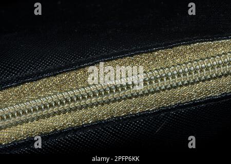 Golden zipped on a black background , Golden plastic zipper Stock Photo