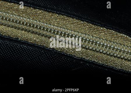 Golden zipped on a black background , Golden plastic zipper Stock Photo
