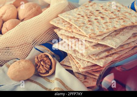 Passover celebration concept. Matzah, red kosher and walnut. Traditional ritual Jewish bread matzah, kippah and tallit on old wooden background. Passo Stock Photo