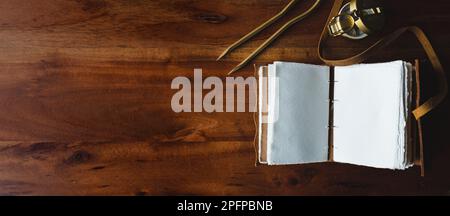 Vintage leather journal or diary on a black table with a compass next to it Stock Photo