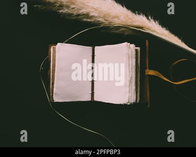 Vintage leather journal or diary on a black table with a compass next to it Stock Photo