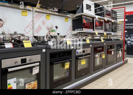 Gas and electric ovens, stoves and other appliance or equipment in the retail store showroom. Minsk, Belarus, 2023 Stock Photo
