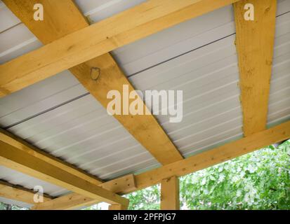 Close-up of wooden roof rafters with metal corrugated board, bottom view Stock Photo