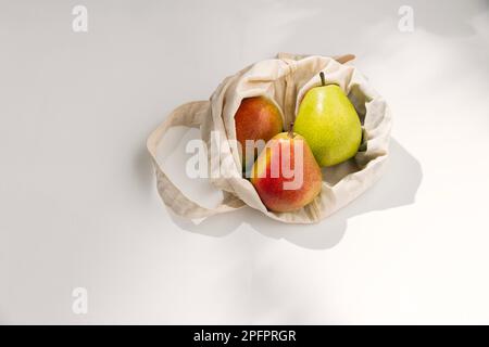 Fresh organic pears on the textile napkin on the table under the sun with some shadows Stock Photo