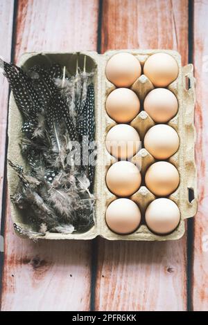Eggs in egg box with feather Stock Photo