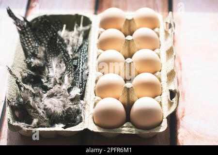 Eggs in egg box with feather Stock Photo