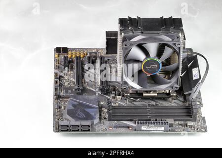 Heat sink or computer processor cooler or radiator on computer motherboard, Active CPU cooler with fan, aluminum fin and heat pipe on computer mainboard. Stock Photo