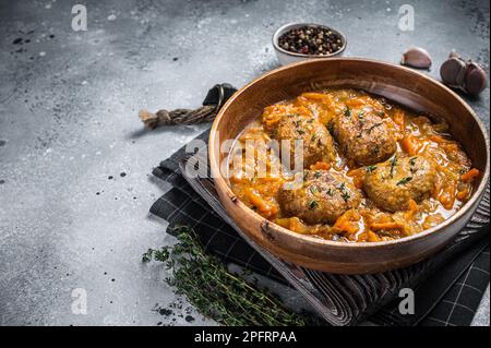 Cutlets or Fish balls with tuna in tomato sauce. Gray background. Top view. Copy space. Stock Photo