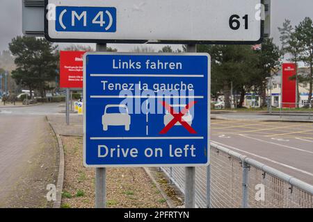 Roadsign at Fishgaurd custom’s reminding drivers to drive on left hand side of road in German and French language Stock Photo