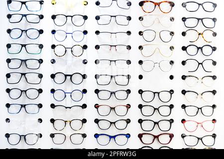 Fashionable corrective eye glasses on shelf in optical store. Many types of glasses. Fashion collection set glasses Stock Photo
