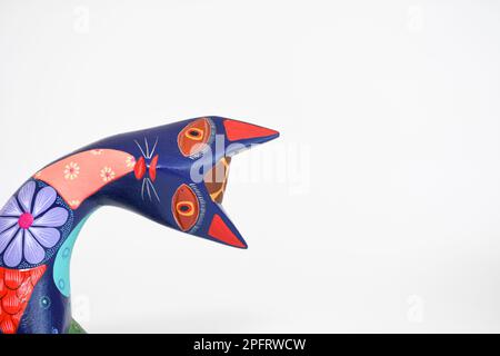 Colorful alebrije. Mexican hand painted wooden handicraft in the shape of a cat on a white background. Oaxaca, Mexico. Copy space Stock Photo