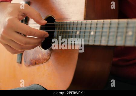 Close-up of mans hands playing an acoustic guitar. Playing the guitar, musical background Stock Photo