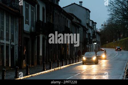 The vibrant city streets of Santiago de Compostela, Spain, are drenched in rain on a dark and moody night Stock Photo