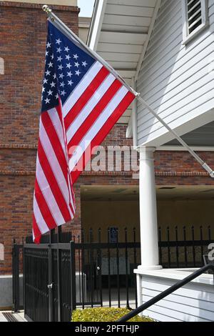 Closeup of an American Flag on the front porch of an older style home. Stock Photo