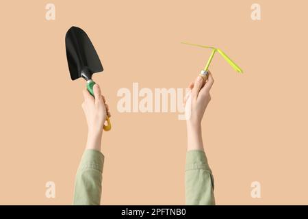 Female gardener with tools on beige background Stock Photo