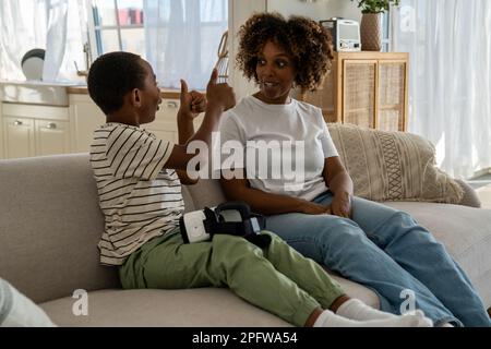 Happy child African American boy feeling excited by receiving virtual reality headset as gift Stock Photo