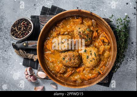 Cutlets or Fish balls with tuna in tomato sauce. Gray background. Top view. Stock Photo