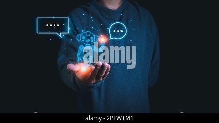 A person stretches out his hand with a model of a robot on his palm. Demonstrates the use of ai and chat GPT systems to research and work. Stock Photo
