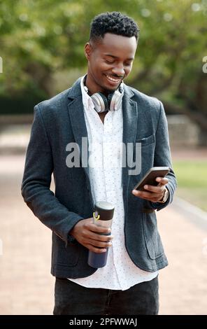 Every post keeps his followers captivated. a young businessman using a smartphone against an urban background. Stock Photo