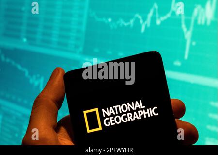 China. 19th Feb, 2023. In this photo illustration, the American science, culture and nature magazine and digital cable and television network National Geographic (NG) logo is seen displayed on a smartphone with an economic stock exchange index graph in the background. Credit: SOPA Images Limited/Alamy Live News Stock Photo