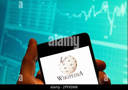 China. 15th Feb, 2023. In this photo illustration, the multilingual, web-based, free encyclopedia Wikipedia logo seen displayed on a smartphone with an economic stock exchange index graph in the background. (Credit Image: © Budrul Chukrut/SOPA Images via ZUMA Press Wire) EDITORIAL USAGE ONLY! Not for Commercial USAGE! Stock Photo