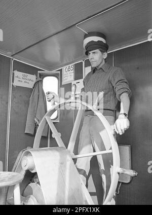 At the rudder. A man at the rudder steer the ship on course, he looks focused on what's ahead.     Sweden 1970 ref ED1 Stock Photo
