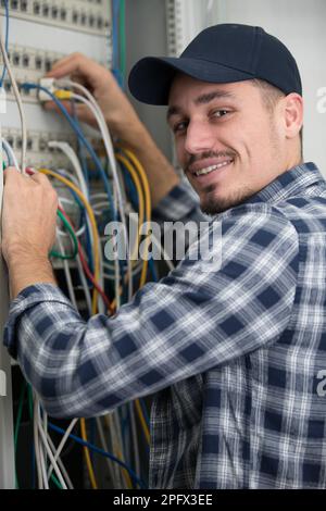 male technician connecting cables to server Stock Photo