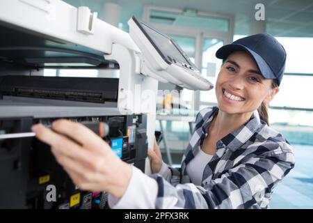 a woman fixing a printer Stock Photo