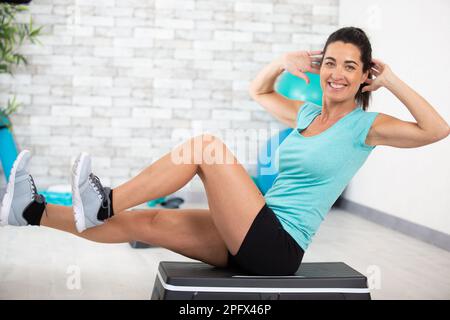 a happy woman doing abdominal at home Stock Photo