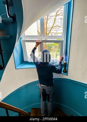 Paris, France, French Worker Installing New Double-Pane WIndows in Apartment Building Coop Stairway, home efficiency europe Stock Photo