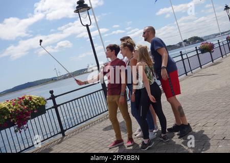 family taking pictures on the waterfront in Cobh, Ireland Stock Photo