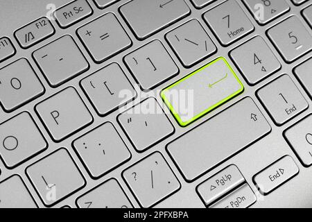 Laptop keyboard with enter key highlighted in light green Stock Photo