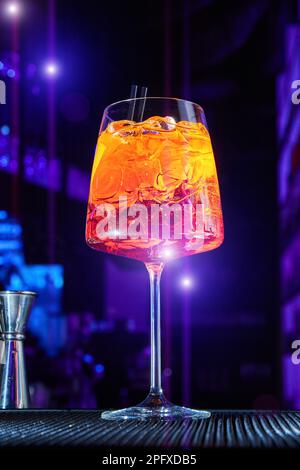 Alcoholic cocktail with ice and a piece of orange on the bar counter Stock Photo