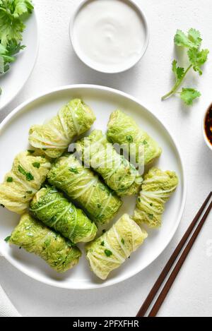 Chinese style stuffed cabbage rolls over white stone background. Top view, flat lay Stock Photo